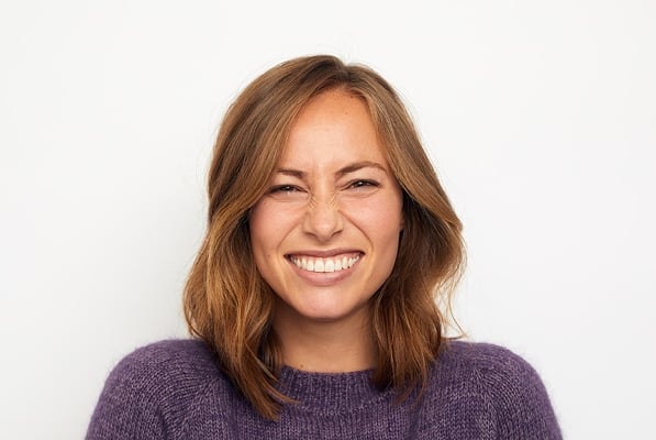 Žena ve fialovém svetrů dělá grimasy