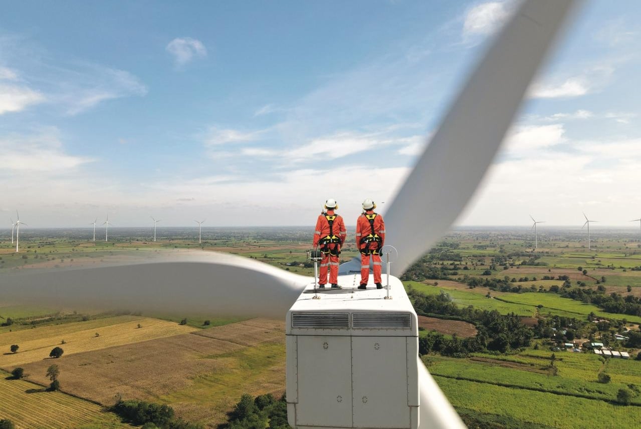 Dva muži na vrcholu větrné elektrárny