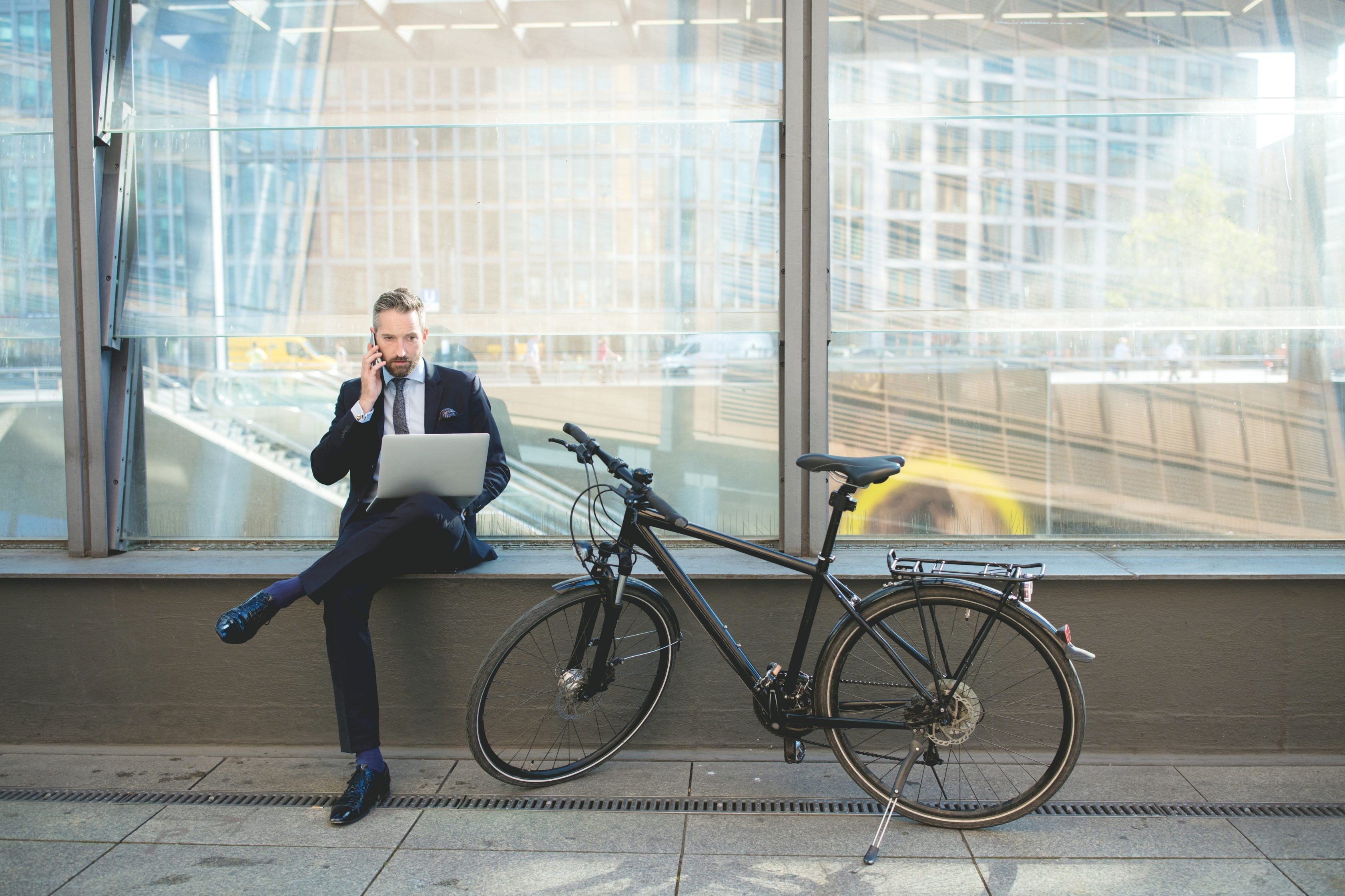 Businesman s laptopem a bicyklem