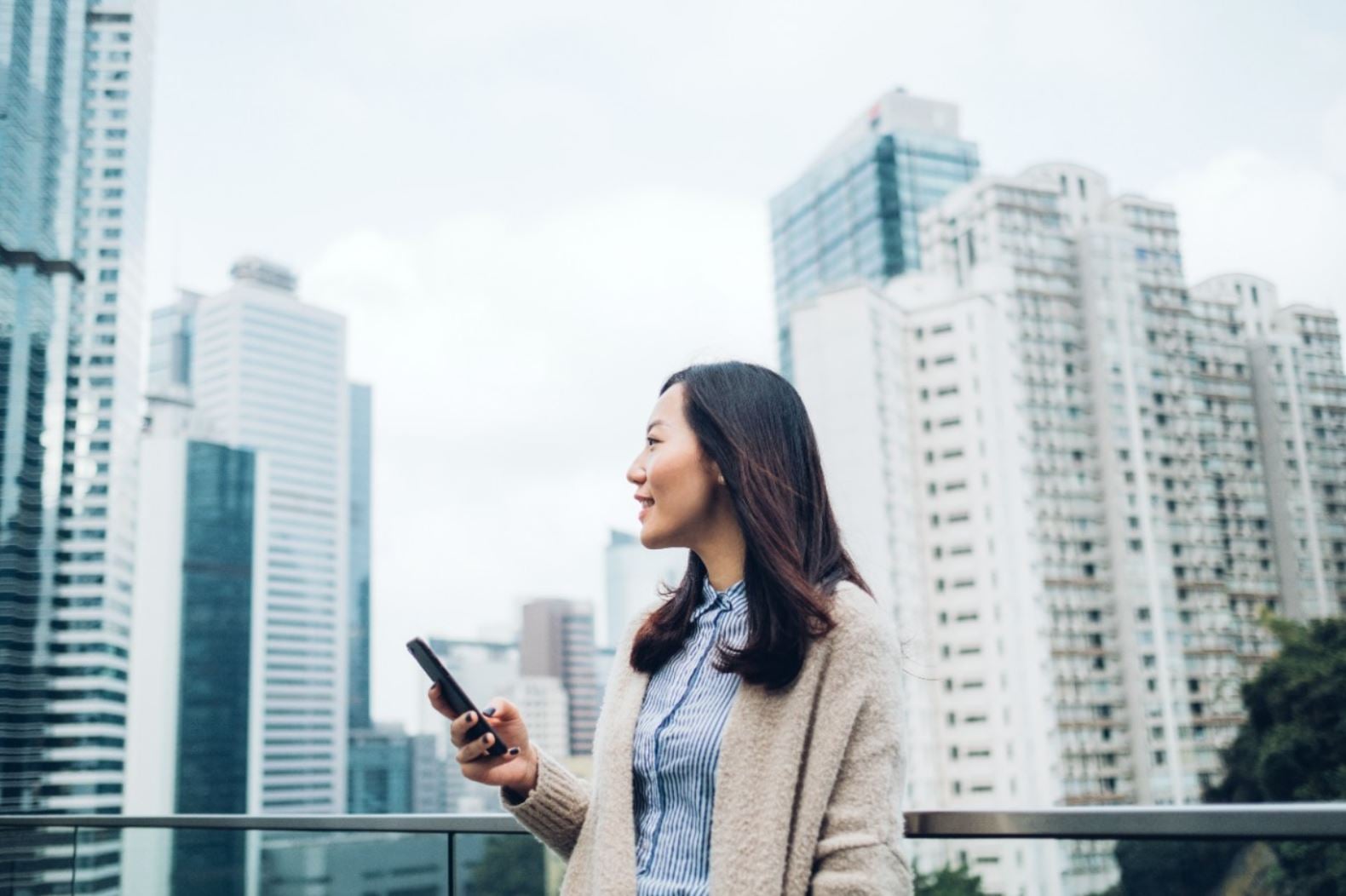 Asijská žena v městě s mrakodrapy