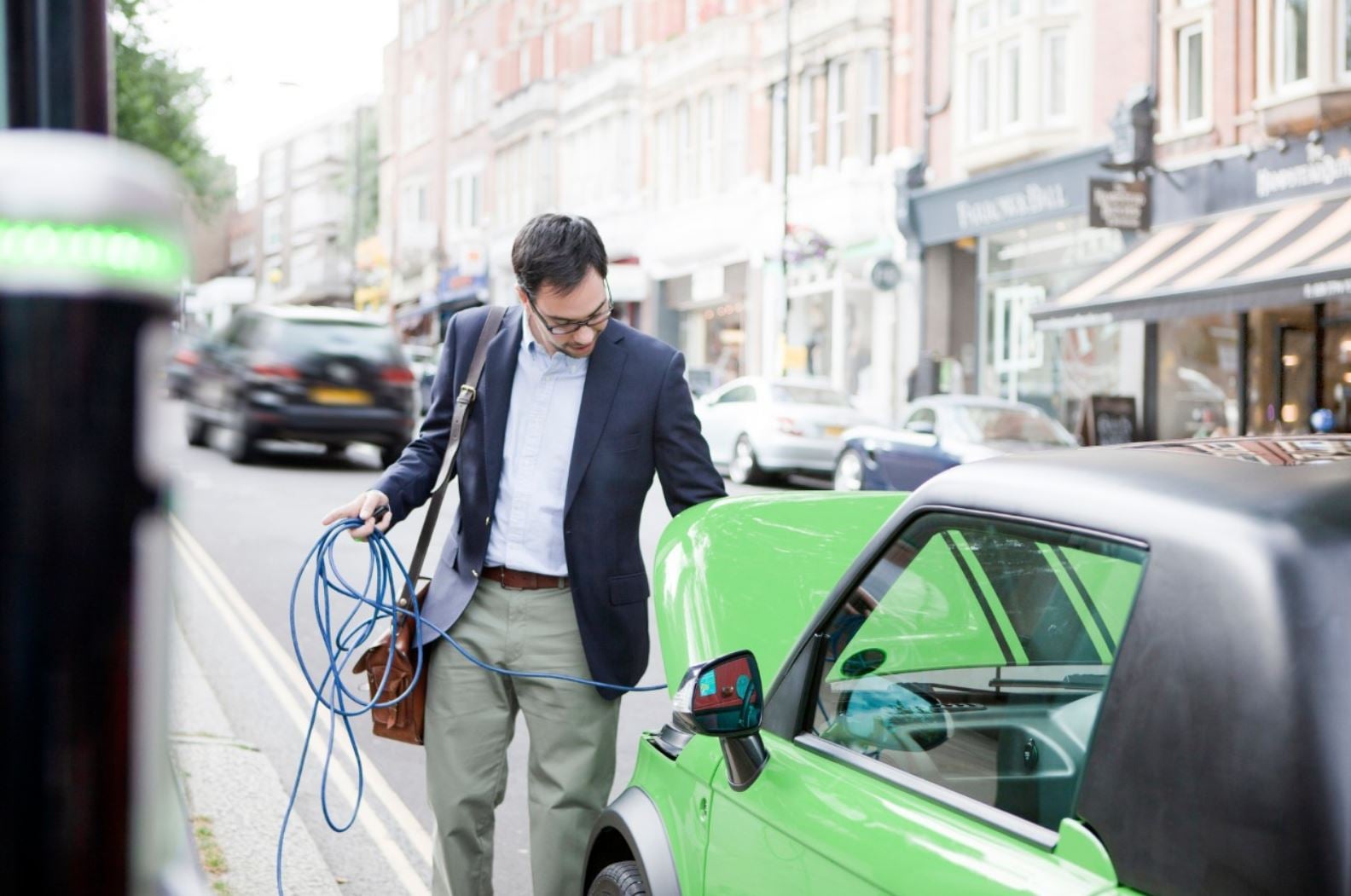 Muž dobíjí elektromobil